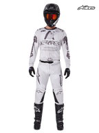 Alpinestars 2025 Racer Hollow MX-utrustningsset, motocross-tröja och byxor i ljus kamouflagebrun och vit, studiovy framifrån på en modell som bär matchande hjälm, handskar och stövlar
