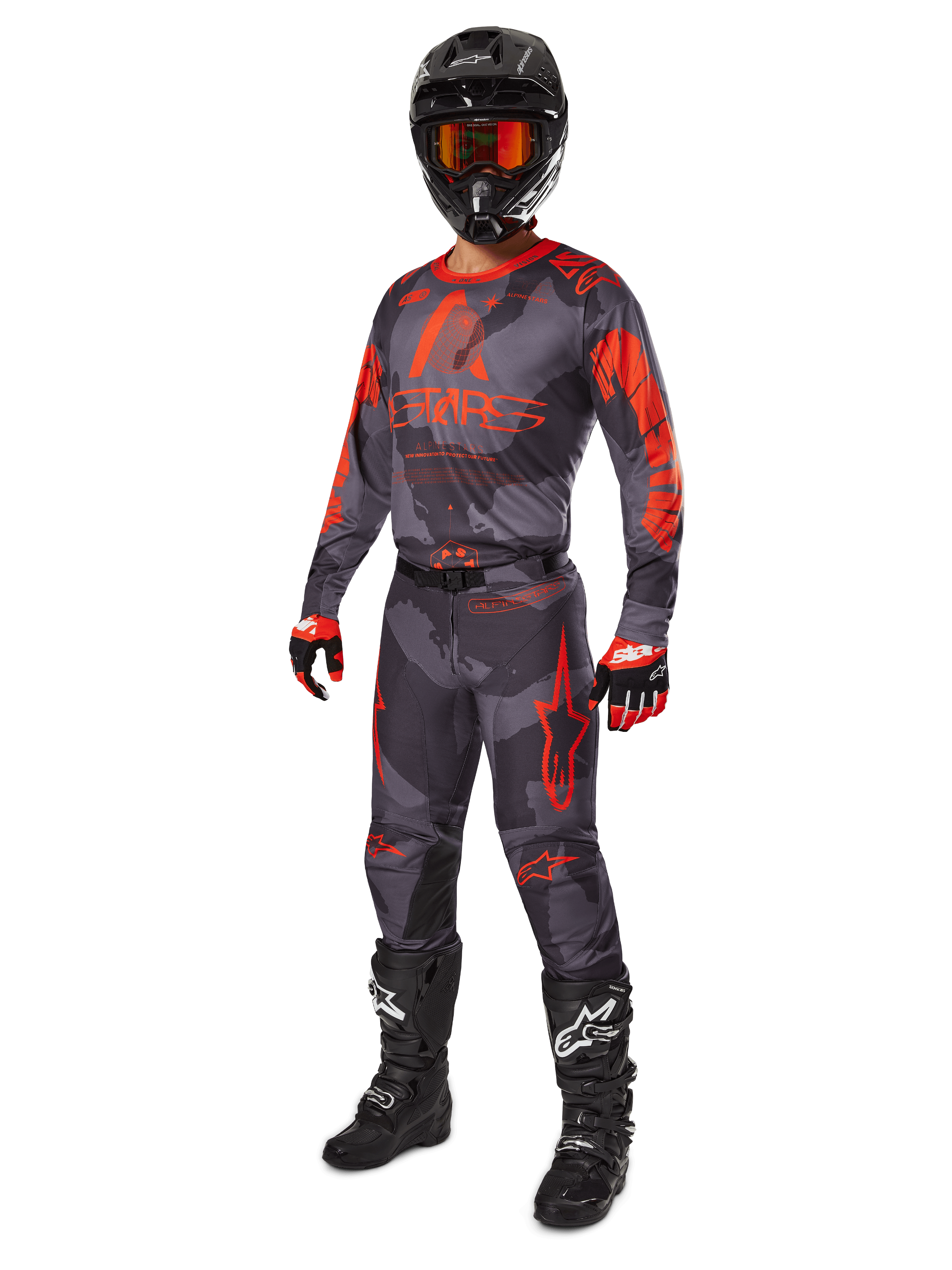 Motocross rider wearing complete racing gear, Alpinestars 2025 Racer Hollow Jersey and Pants in Gray Camo Orange Fluo, black helmet with orange goggles, black and red gloves, and black boots with white logos, coordinated performance outfit for off-road racing