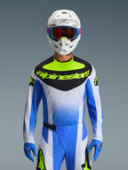 Alpinestars 2026 Techstar Knif utrustningsset, motocrossförare klädd i blå, vit och neongul racingutrustning, tröja med svart bröstpanel och neongul logotyp, vit hjälm med flerfärgade goggles, matchande blå handskar och byxor, högpresterande atletisk tävlingsoutfit för terrängkörning