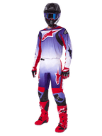 Motocross rider wearing the Alpinestars 2025 Fluid Wurx Gear Set, purple and bright red jersey with white accents, matching motocross pants, bright red boots, black helmet with blue goggles, and red and black gloves, full professional off-road racing kit