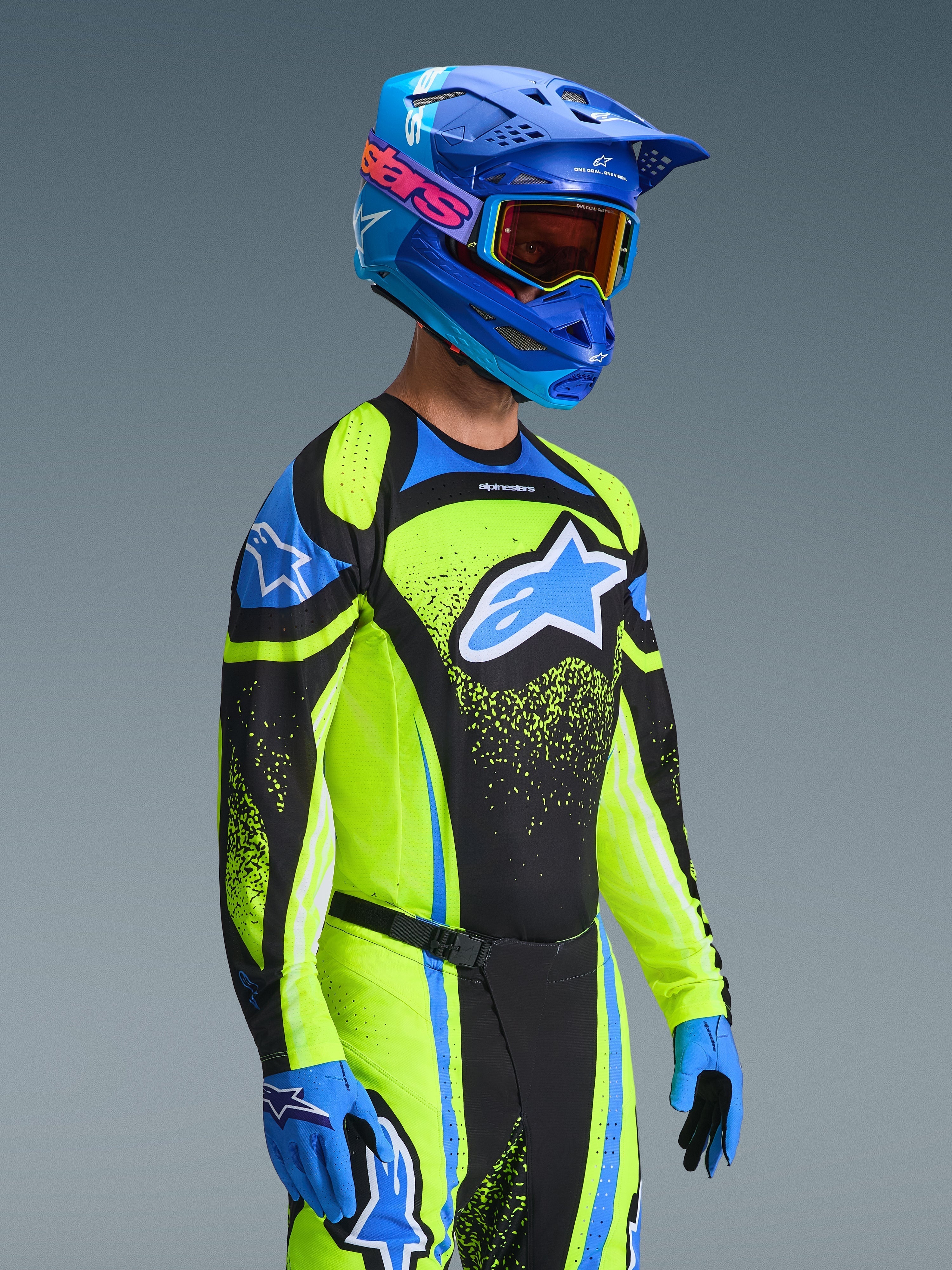 Motocrossförare i 2026 Techstar Nomur-tröja i Dark Navy och Yellow Fluo, matchande byxor, blå racinghjälm och goggles, med en stor Alpinestars-logotyp och atletisk tävlingspassform för terrängkörning.