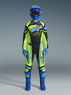 Motocrossförare iklädd komplett racingutrustning, 2026 Techstar Nomur-tröja i gul fluo och mörk marinblå, matchande motocrossbyxor, blå hjälm med rödfärgade goggles, blå handskar och blå stövlar, koordinerad professionell outfit för terrängkörning