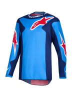 Alpinestars 2026 Fluid Grid tröja, motocrosströja, blå och röd, med stora röda Alpinestars-stjärnlogotyper, mörkblå sidopaneler och lättviktig polytygskonstruktion med förlängt ryggparti för terrängkörning.