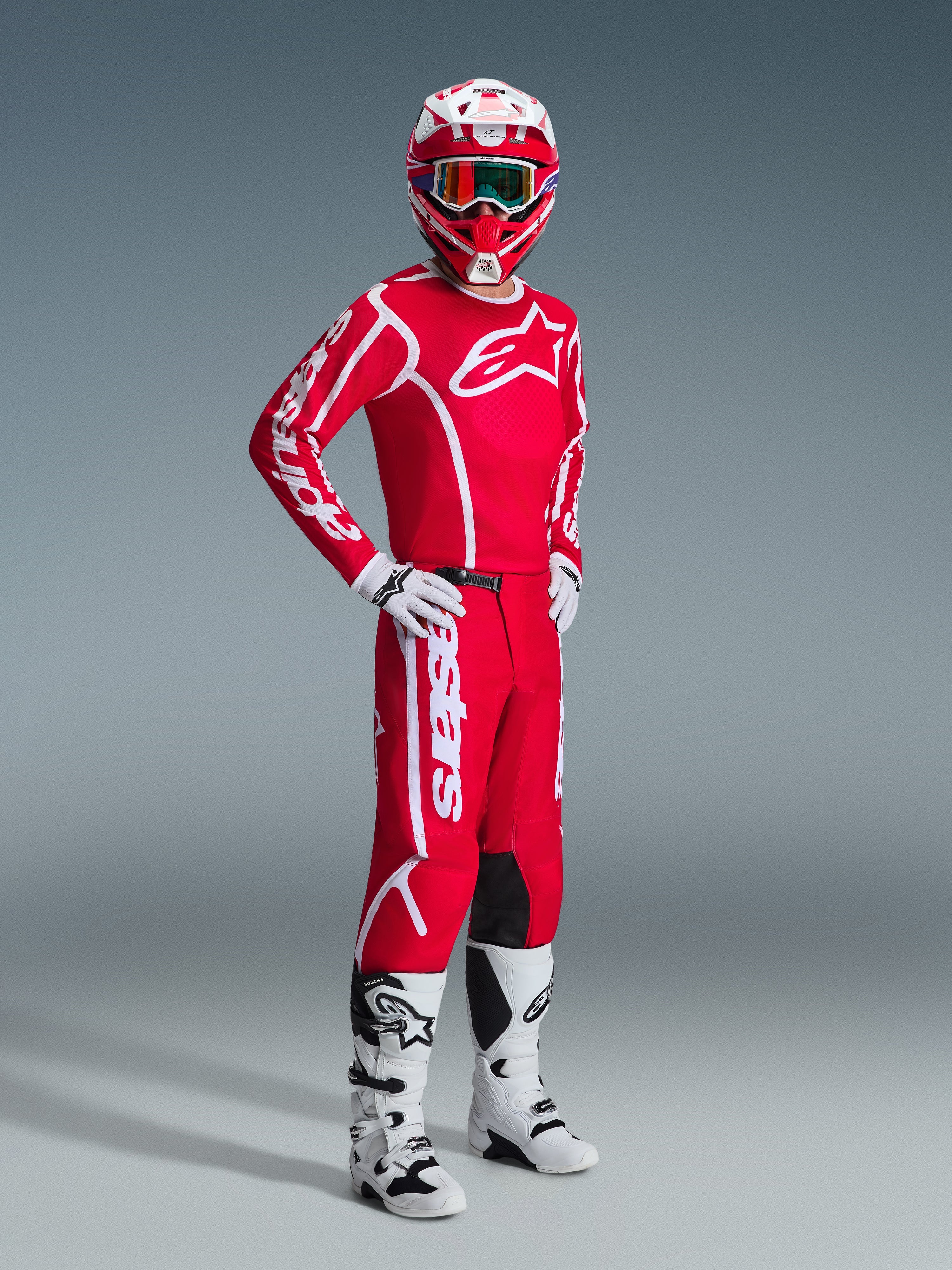 Motocrossförare i Alpinestars 2026 Fluid Apex utrustningsset, röd tröja med stora vita logotyper, matchande röda byxor med vit branding, vit och röd hjälm, vita motocross-stövlar och handskar, koordinerad outfit för terrängkörning
