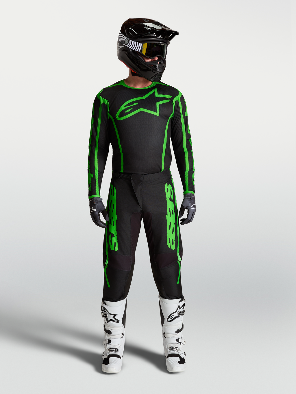 Alpinestars Fluid Apex V2 byxor, motocrossutrustning för herr, svart och grön fluo, komplett racingoutfit med vita stövlar.