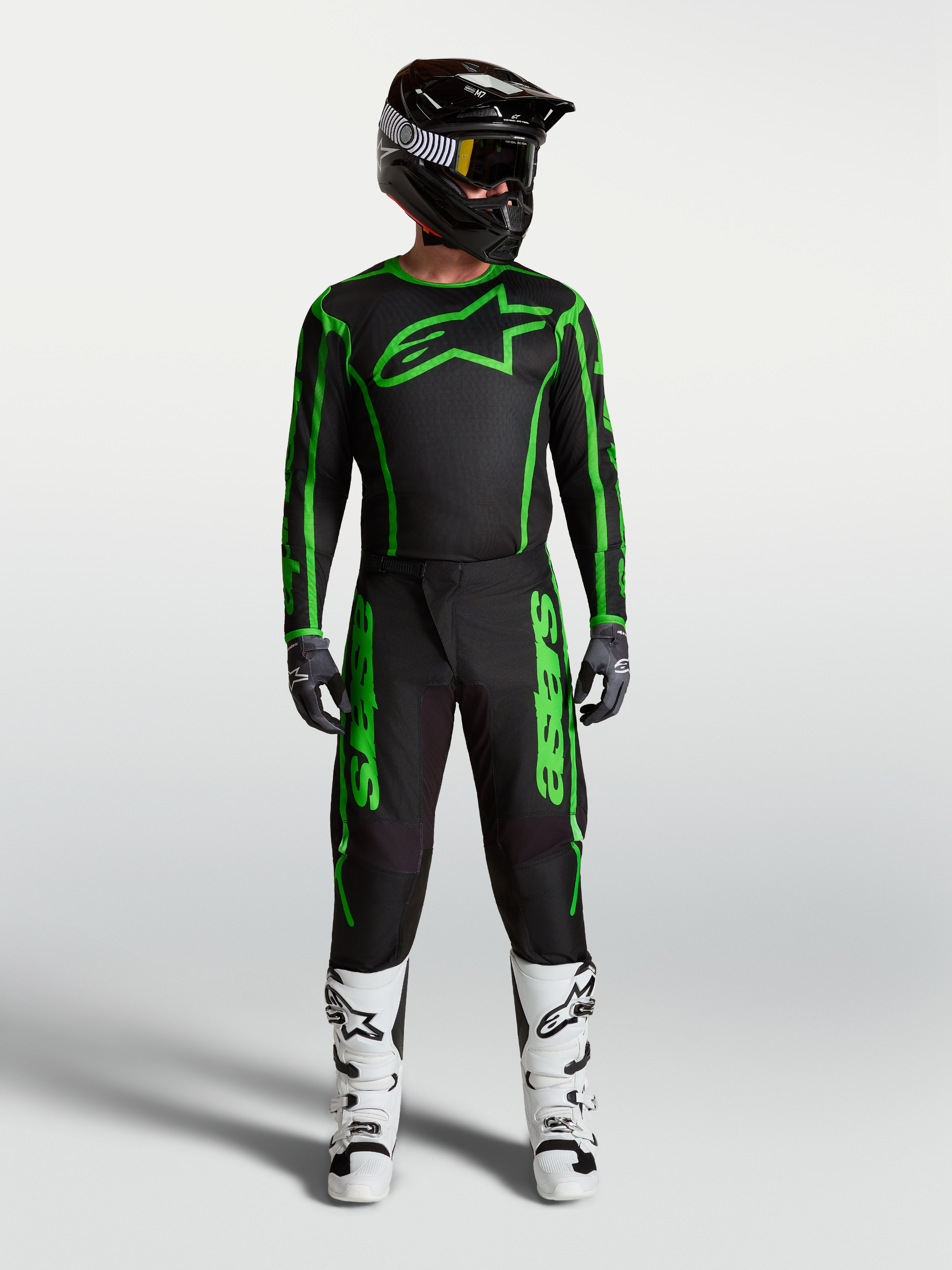 Alpinestars Fluid Apex V2 byxor, motocrossutrustning för herr, svart och grön fluo, komplett racingoutfit med vita stövlar.