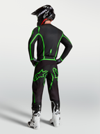 Alpinestars Fluid Apex V2 Byxor, motocrossbyxor för herr, svarta och gröna fluo, ergonomisk racingpassform visas bakifrån i ett komplett gear set för terrängkörning.