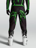 Alpinestars Fluid Apex V2 byxor, svarta och gröna motocrossbyxor för herr med stor stjärngrafik, vy bakifrån på modell.