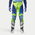 Alpinestars 2024 Racer Hoen Pants, Motocross Pants, Yellow Fluo and Blue Night Navy, worn with white and black motocross boots and blue gloves, featuring bold red logos, light blue knee panels, and a sporty ergonomic design for off-road riding