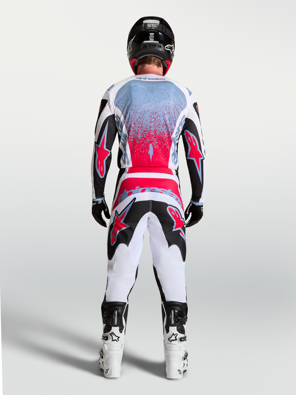 Alpinestars Fluid Drag tröja, motocrosströja för herr, svart och röd fluo med vita detaljer, vy bakifrån på en förare, ergonomisk design för optimal rörlighet vid terrängkörning.