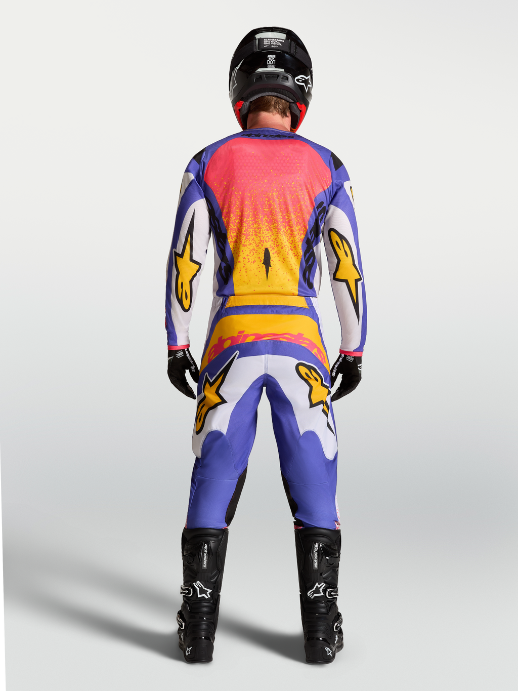 Alpinestars Fluid Drag byxor och klädset, motocrossutrustning för herrar i lila, blått och guld, vy bakifrån på modell.