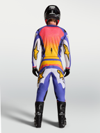 Alpinestars Fluid Drag byxor och klädset, motocrossutrustning för herrar i lila, blått och guld, vy bakifrån på modell.