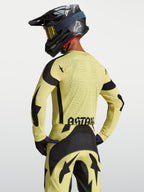 Alpinestars Techstar Atrox tröja, herrtröja för motocrossracing, gul och svart, bärs av modell bakifrån med laserperforeringar och stor ASTARS-grafik på ryggen.