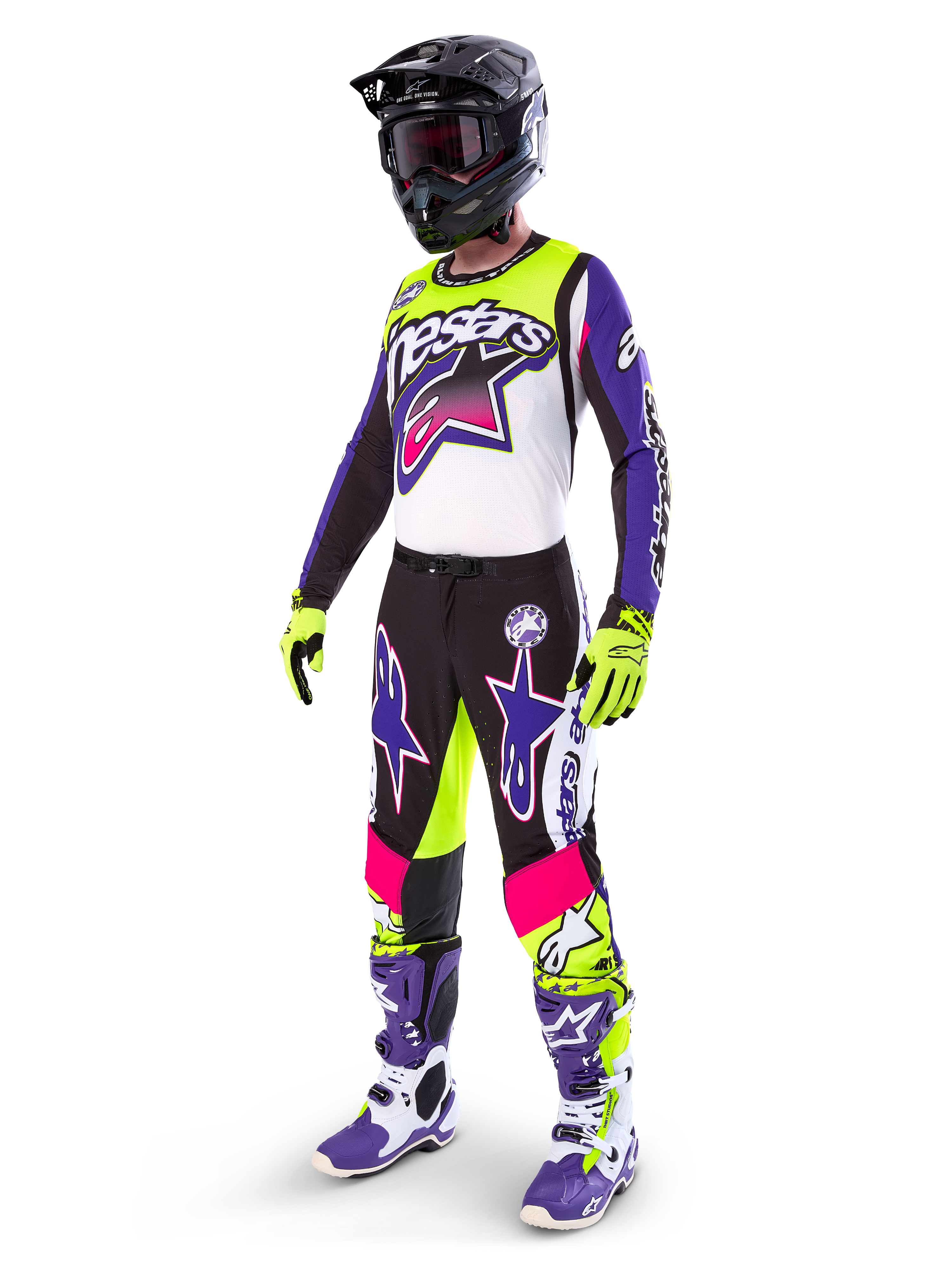 Motocrossförare i Alpinestars Limited Edition Supertech Dirt Studios®-utrustning, färgkombination i vitt, lila och neongult, svarta byxor med lila och rosa stjärnlogotyper, neongula handskar, lila och vita racingstövlar, svart hjälm, komplett professionell racingutrustning för terrängkörning
