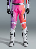 Alpinestars 2026 Racer Air Portl-byxor, motocrossbyxor, livfull gradient i lila, rosa och orange, framträdande stjärnlogotyper på låren, bärs med vita racingstövlar och svarta handskar, designade för högpresterande terrängkörning