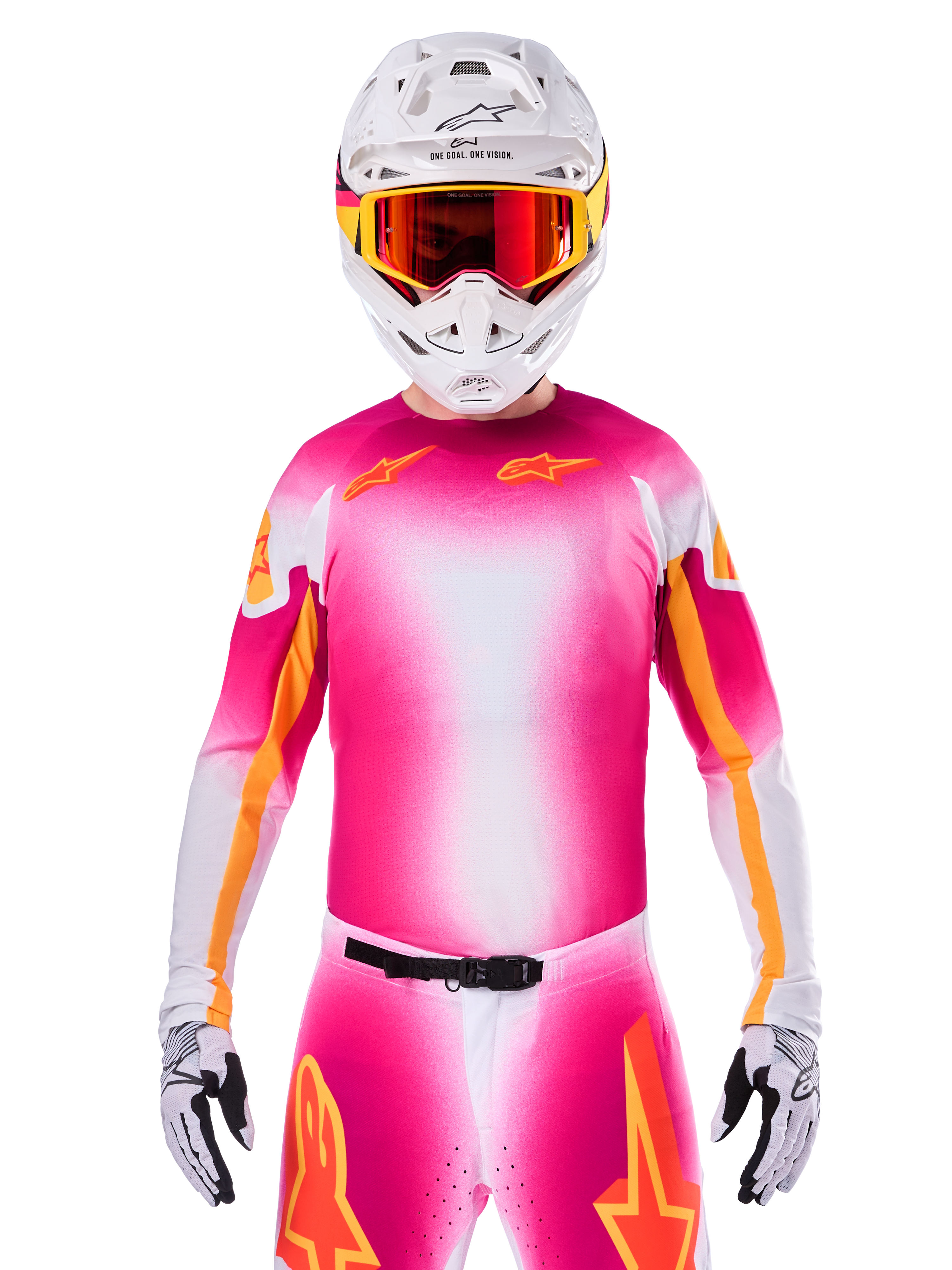 Alpinestars Limited Edition Supertech AFD MIG-tröja, rosa och vit motocrosströja med en livfull färgtoning och orangea stjärnlogotyper, bärs som ett komplett racingställ med matchande byxor, vit hjälm och röda goggles, professionell utrustning för terrängkörning