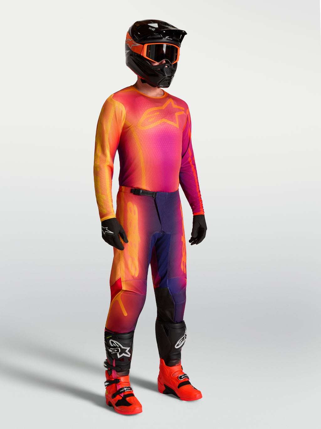 Alpinestars Fluid Kepler tröja, lila och orange motocrosströja på modell med matchande racingutrustning.