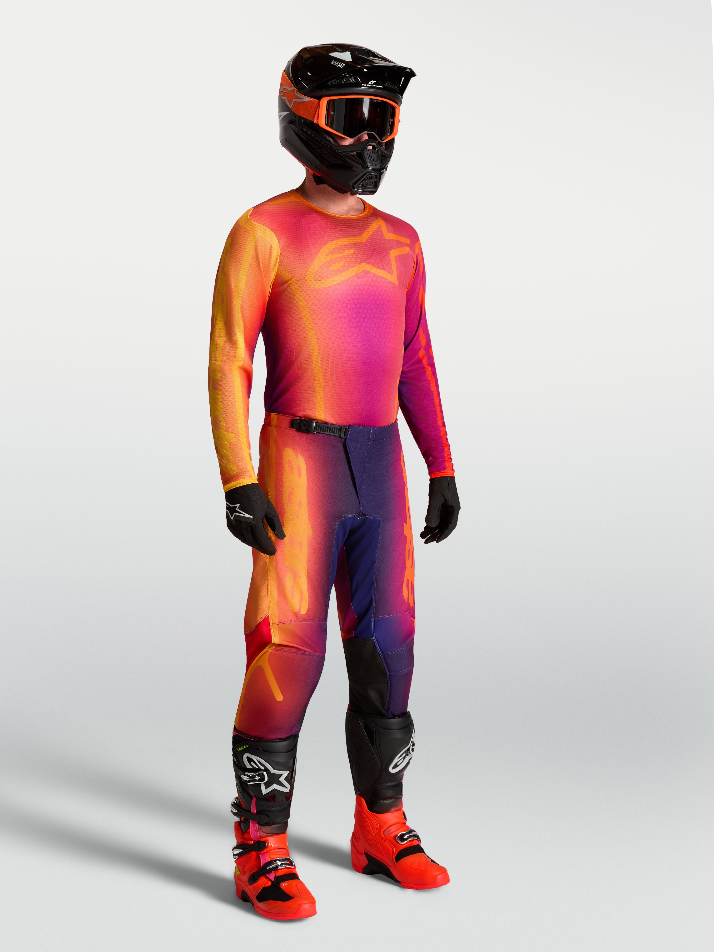 Alpinestars Fluid Kepler tröja, lila och orange motocrosströja på modell med matchande racingutrustning.