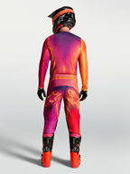 Alpinestars Fluid Kepler lila och orange motocrossbyxor, vy bakifrån på modell med matchande tröja och stövlar.