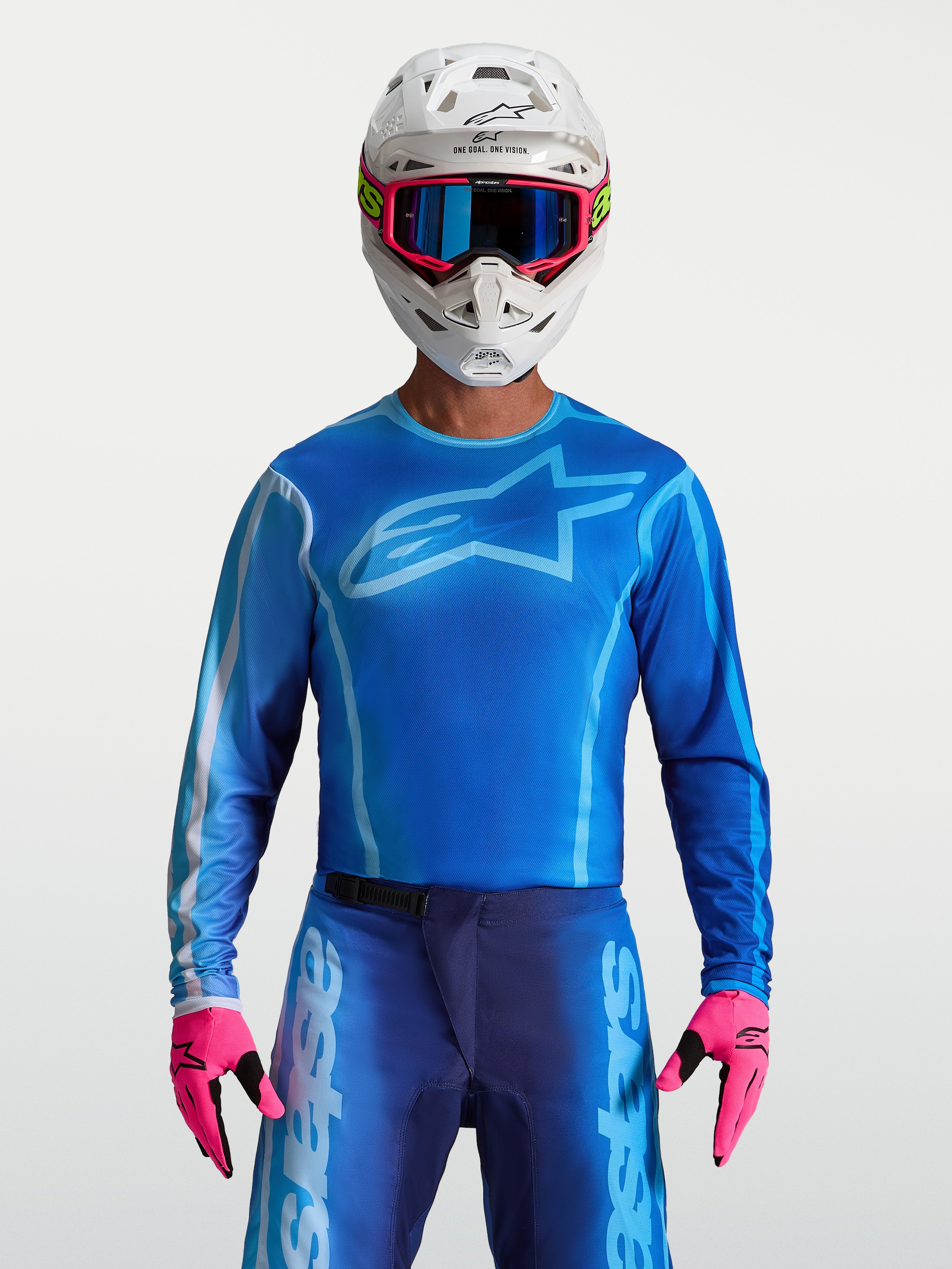 Alpinestars Fluid Kepler tröja, motocrosströja för herr, blå och ljusblå, på modell med matchande byxor och hjälm, lätt polyfabrikskonstruktion för optimal rörlighet vid terrängkörning.