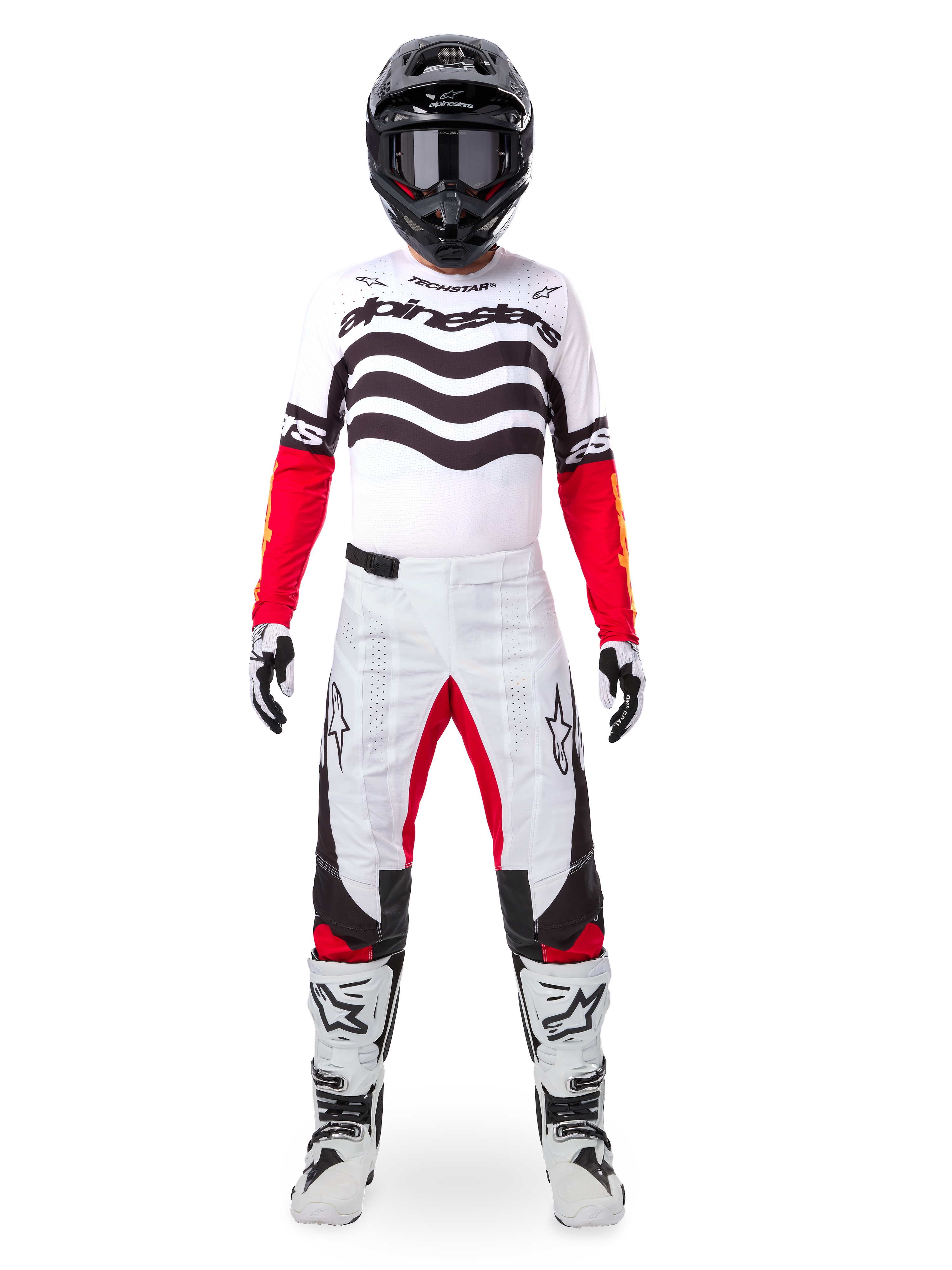 Motocross rider wearing the Alpinestars Limited Edition Techstar Deep Gear Set, white jersey with black wave graphics and red sleeves, matching white and black pants with red inner thigh accents, black helmet with dark goggles, and white boots, full professional off-road racing outfit
