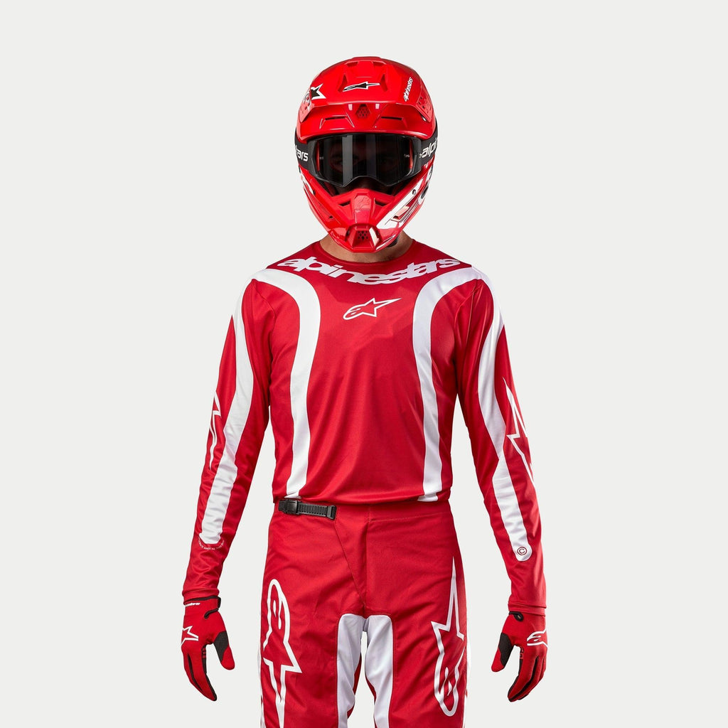 Alpinestars 2024 Fluid Lurv Jersey, motocrosströja, Mars-röd och vit, bärs med matchande röda byxor, hjälm och handskar, vita grafiska detaljer på ärmarna och framträdande logotyp på bröstet, atletisk passform för terrängkörning