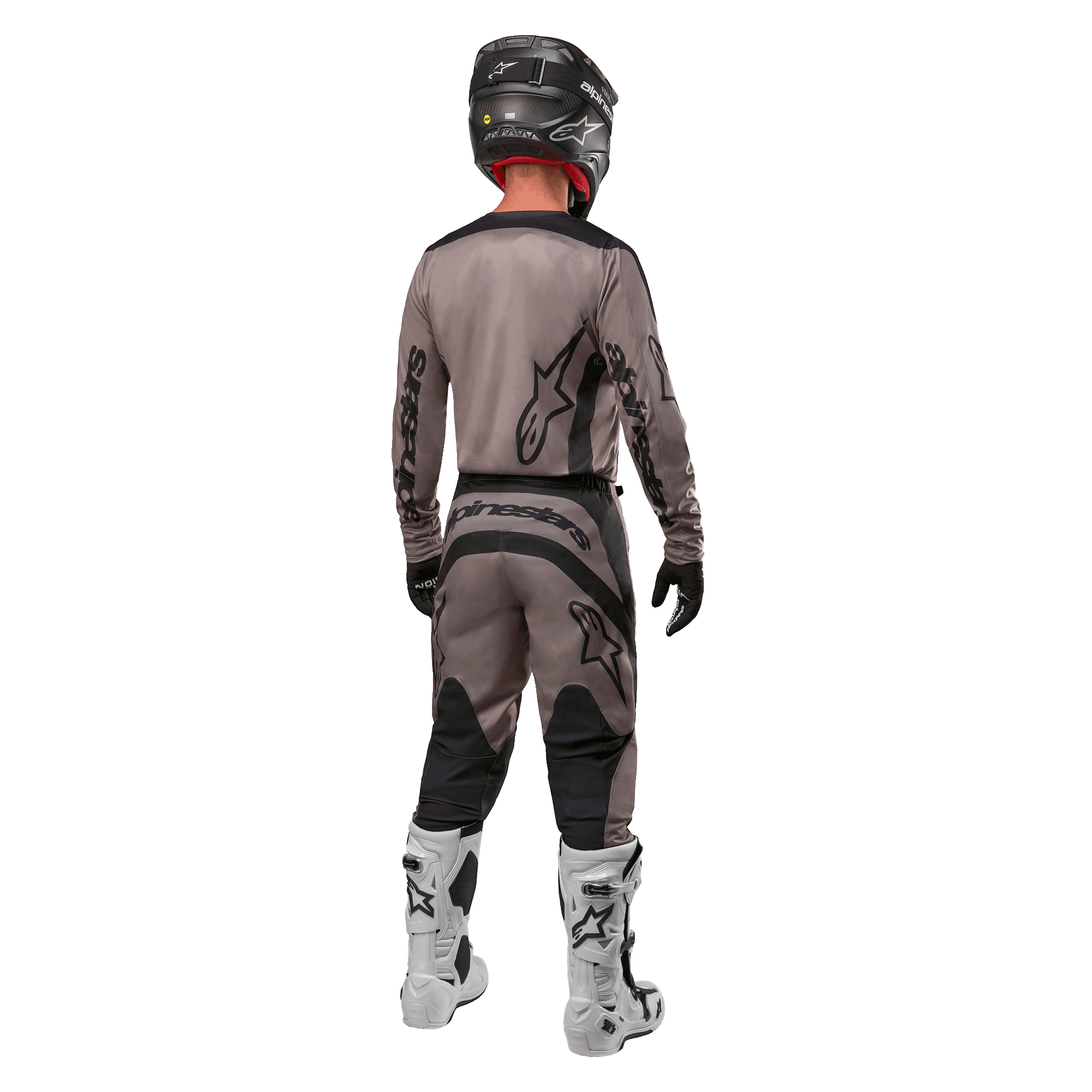 Alpinestars 2024 Fluid Lurv tröja, motocrosströja, Mud Black, bakifrån av en motocrossförare som bär matchande racingutrustning, svart hjälm och vita stövlar, med framträdande svarta Alpinestars-logotyper och en atletisk passform för terrängkörning.
