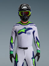 Alpinestars 2026 Supertech Vista Jersey, Motocross Jersey, Light Gray Yellow Fluo and Blue, worn by a rider with matching pants and black helmet, featuring a large chest logo and laser-cut perforations for ventilation, pro-level athletic fit