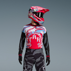 Alpinestars Techstar Beast Coast-set, röd och blå tröja, grå kamouflagebyxor och matchande rosa hjälm med svarta goggles.