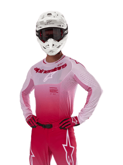 Alpinestars 2024 Supertech Dade-tröja, motocrossutrustning, Red Berry Lilac gradient-design, långärmad tröja med laserskurna perforeringar, förare med vit hjälm och matchande röda handskar och byxor, professionellt motocross-kit på vit bakgrund