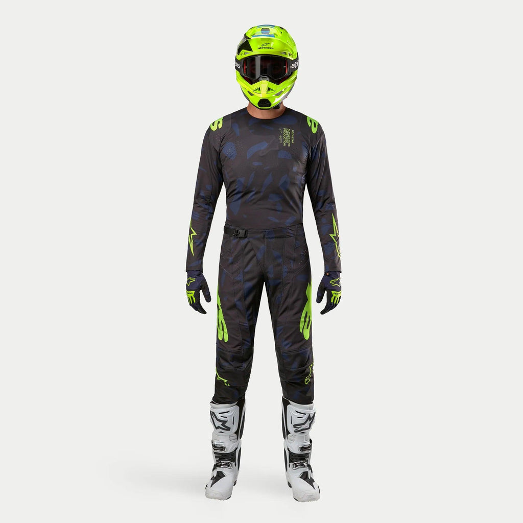 Motocrossförare i komplett racingutrustning, 2024 Techstar Rantera-tröja i Black Navy och Yellow Fluo, matchande byxor med abstrakt tryck, neongul hjälm, vita och svarta stövlar, koordinerad outfit för terrängkörning