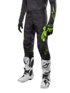 Alpinestars 2024 Techstar Rantera byxor, motocrossbyxor, svarta, marinblå och neongula, med marinblått kamouflagemönster och neongröna logotyper, bärs med matchande handskar och vita stövlar, slitstark racing-fit-design för offroad-prestanda.