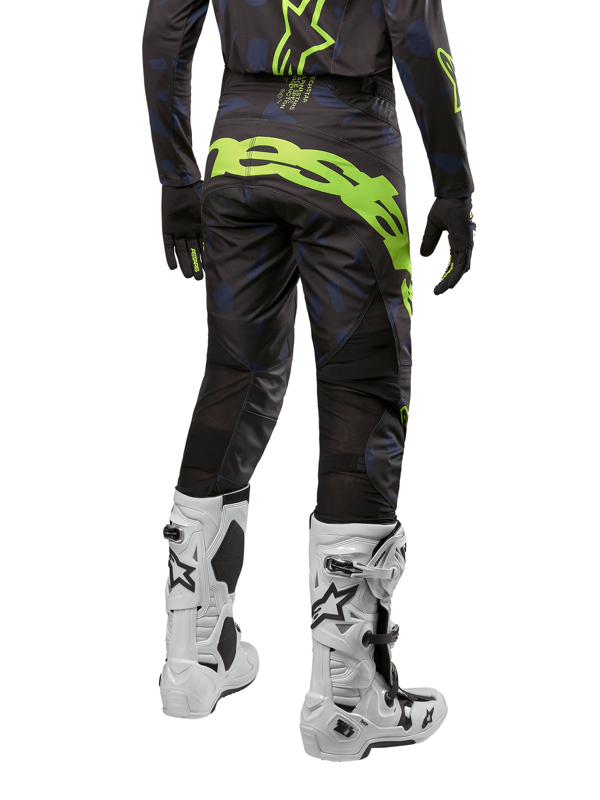Alpinestars 2024 Techstar Rantera byxor, motocrossbyxor, svarta, marinblå och neongula, vy bakifrån, med framträdande neongul logotyp och ventilationspaneler i mesh, bärs med matchande tröja och vita stövlar, slitstark utrustning för motocross och terrängkörning