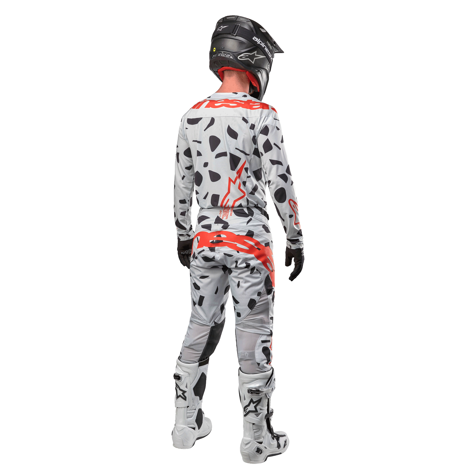 Motocrossförare sedd bakifrån bärandes Alpinestars 2024 Techstar Rantera-tröja och matchande byxor, Haze Gray Camo-mönster med framträdande röda Alpinestars-logotyper, svart hjälm, vita och svarta stövlar, svarta handskar, koordinerat set med motocrossutrustning.