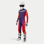 Alpinestars 2024 Techstar Pneuma motocross-set, komplett outfit med tröja och byxor i lila, orange och djupt blått, vit hjälm med svarta goggles, vita stövlar och handskar, professionell racingdesign för terrängkörning.