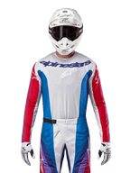 Alpinestars 2024 Techstar Pneuma tröja, motocrosströja, blå, röd och vit, sedd framifrån buren av en förare med vit hjälm och handskar, med laserskurna perforeringar på bröstet och tydlig logotyp, atletiska racingkläder för terrängkörning