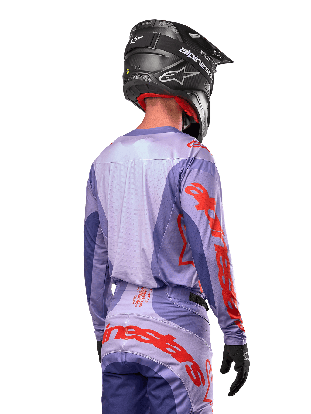 Alpinestars 2024 Techstar Ocuri tröja, motocrosströja, lila och neonorange, vy bakifrån på en förare i matchande utrustning och svart hjälm, med stor orange Alpinestars-text på ärmarna och nedre delen av ryggen