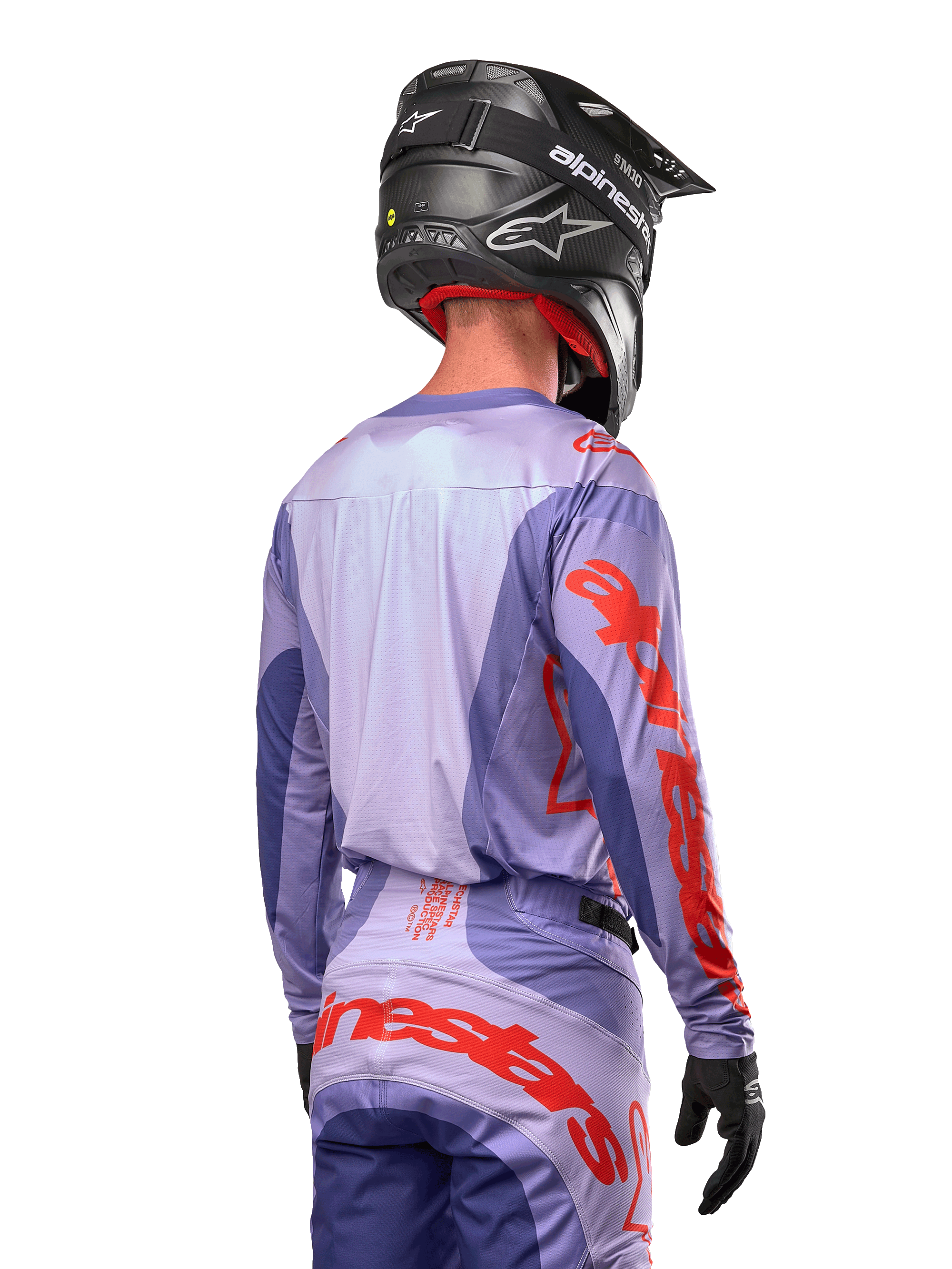 Alpinestars 2024 Techstar Ocuri tröja, motocrosströja, lila och neonorange, vy bakifrån på en förare i matchande utrustning och svart hjälm, med stor orange Alpinestars-text på ärmarna och nedre delen av ryggen