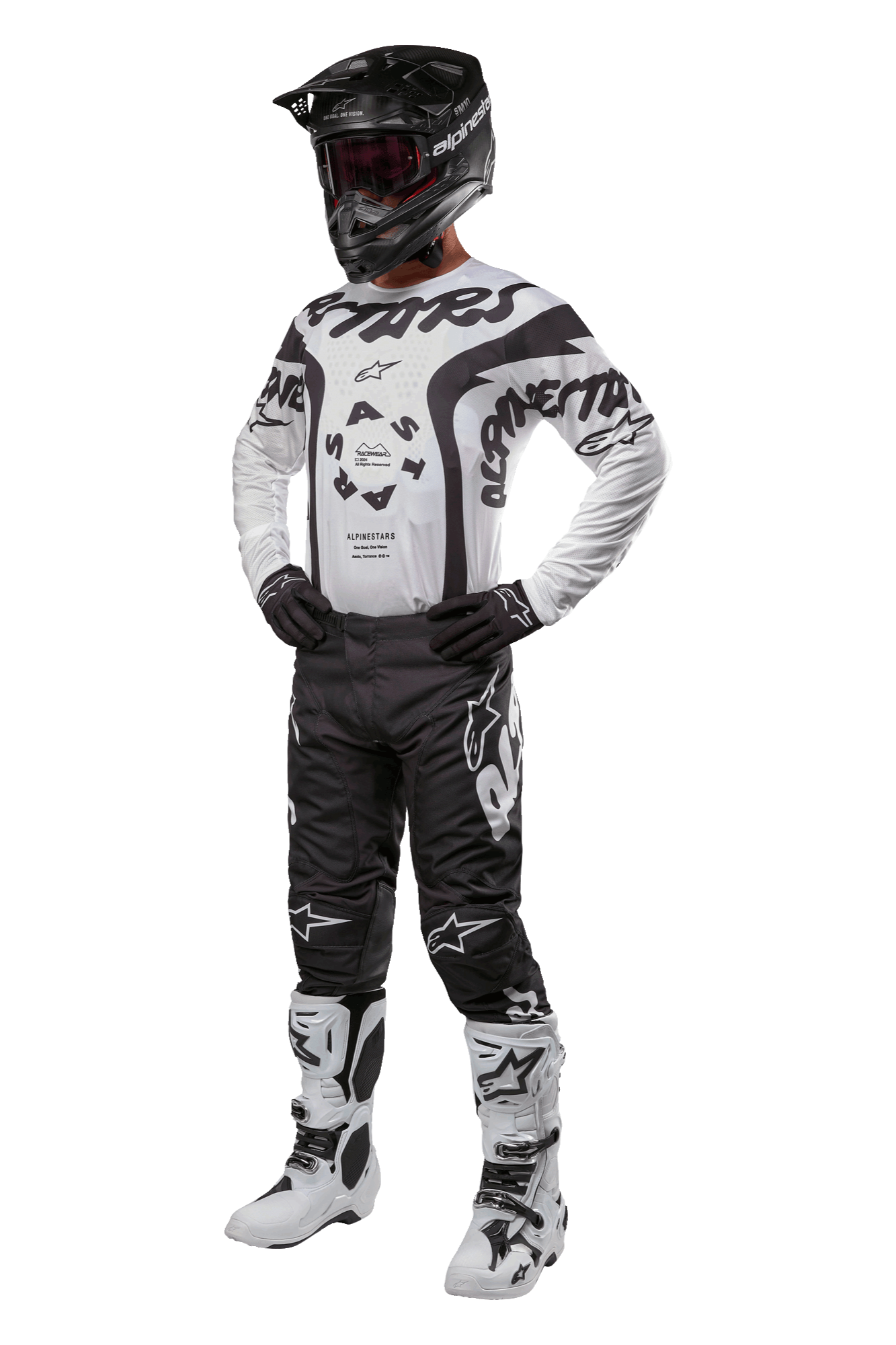 Motocross rider wearing full gear featuring the Alpinestars 2024 Racer Hana Jersey in white and black, black motocross pants with white logos, black helmet, white and black racing boots, and black gloves, professional off-road racing outfit