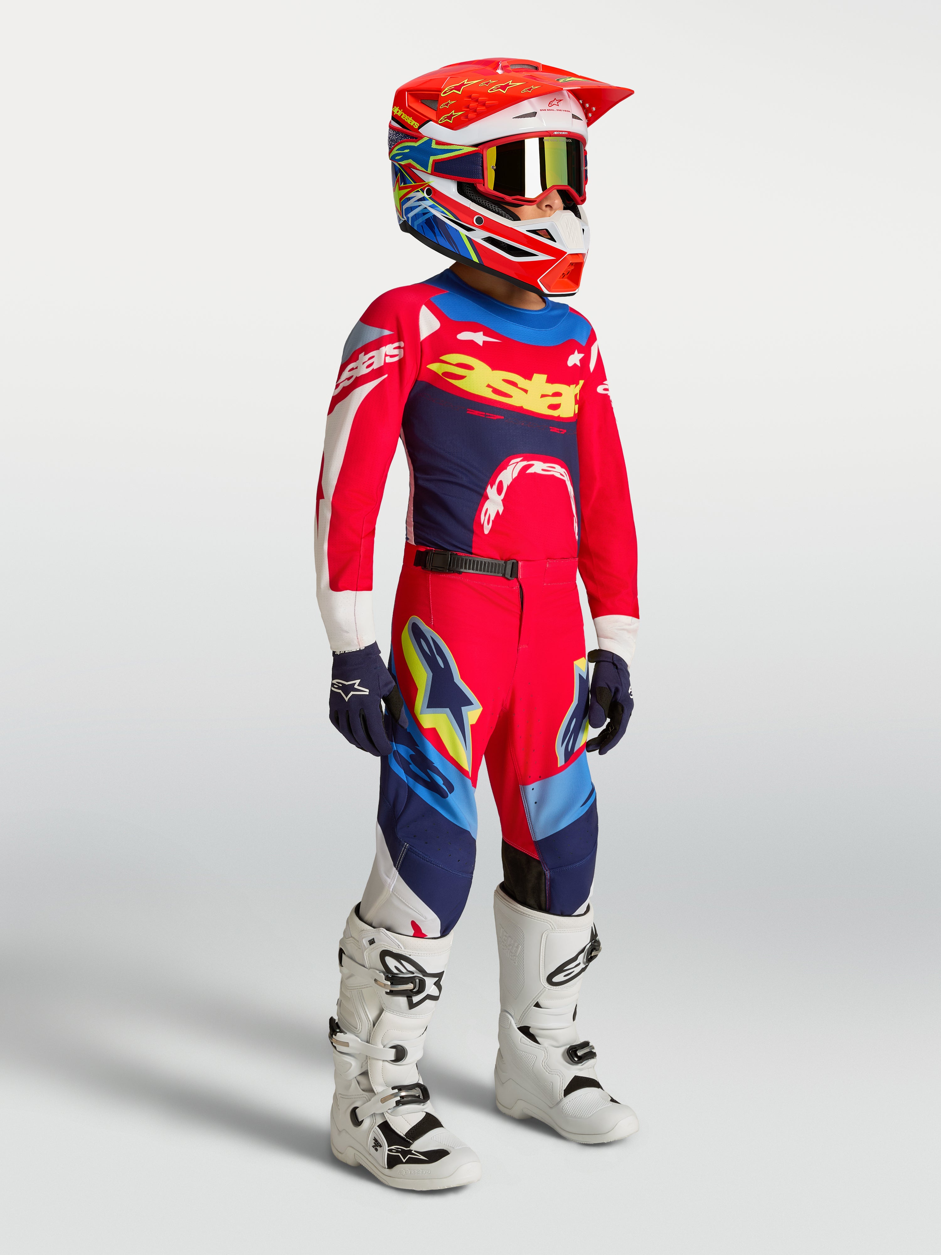 Alpinestars 2027 Ungdom Supertech Dyna tröja och gear set, röd och marinblå motocrossutrustning med vita motorcykelstövlar.