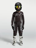Alpinestars 2027 Fluid Apex V2 tröja och gear set för ungdom, svart och silver motocrossutrustning, vita stövlar och svart hjälm