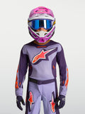 Alpinestars 2027 Ungdom Fluid Hunt tröja, lila och neonrosa motocrosströja, på modell med racinghjälm och goggles.