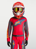 Alpinestars 2027 Fluid Hunt Ungdom Tröja, röd och grå motocrosströja, bärs av modell med racinghjälm för terrängkörning.