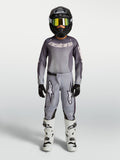 Alpinestars 2027 Ungdom Fluid Amber tröja och set, grå och sandfärgad motocrossutrustning med svart hjälm och vita stövlar.