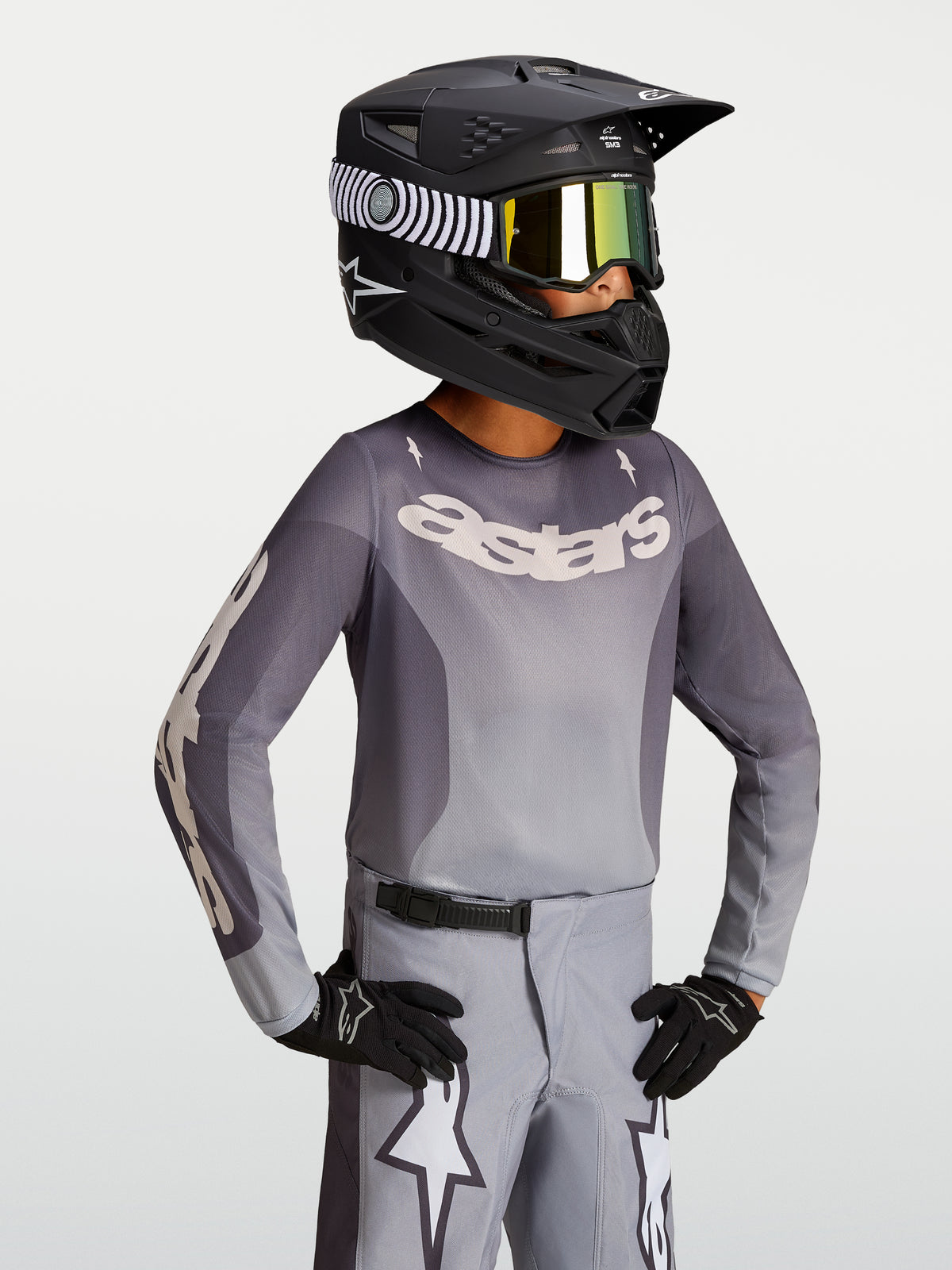 Alpinestars 2027 Ungdom Fluid Amber tröja, motocrosströja i sand och grått, på modell med svart hjälm