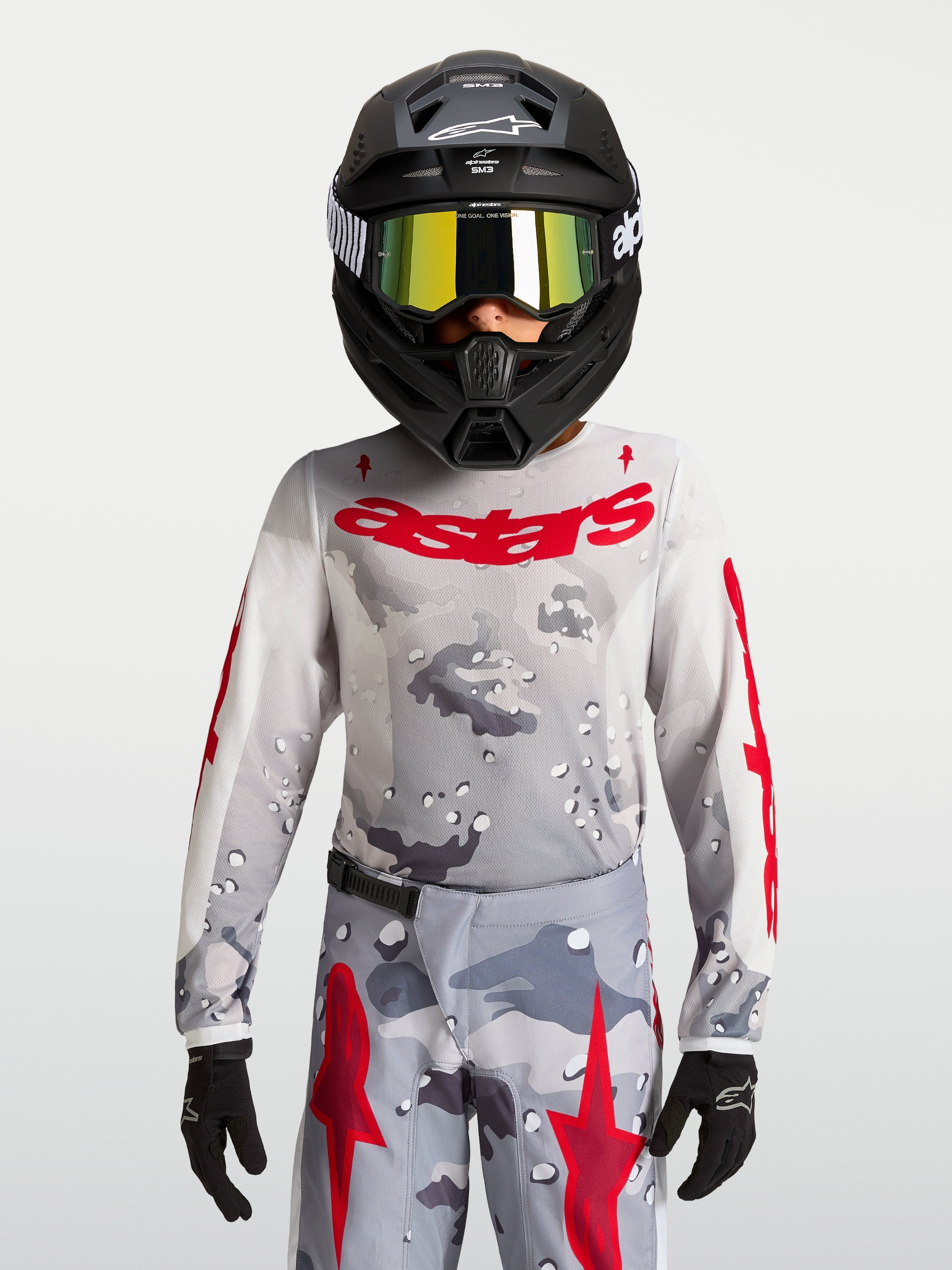 Alpinestars 2027 Ungdom Fluid Lone tröja, grå camo och röd motocrossutrustning, prestandaorienterad textilkonstruktion.