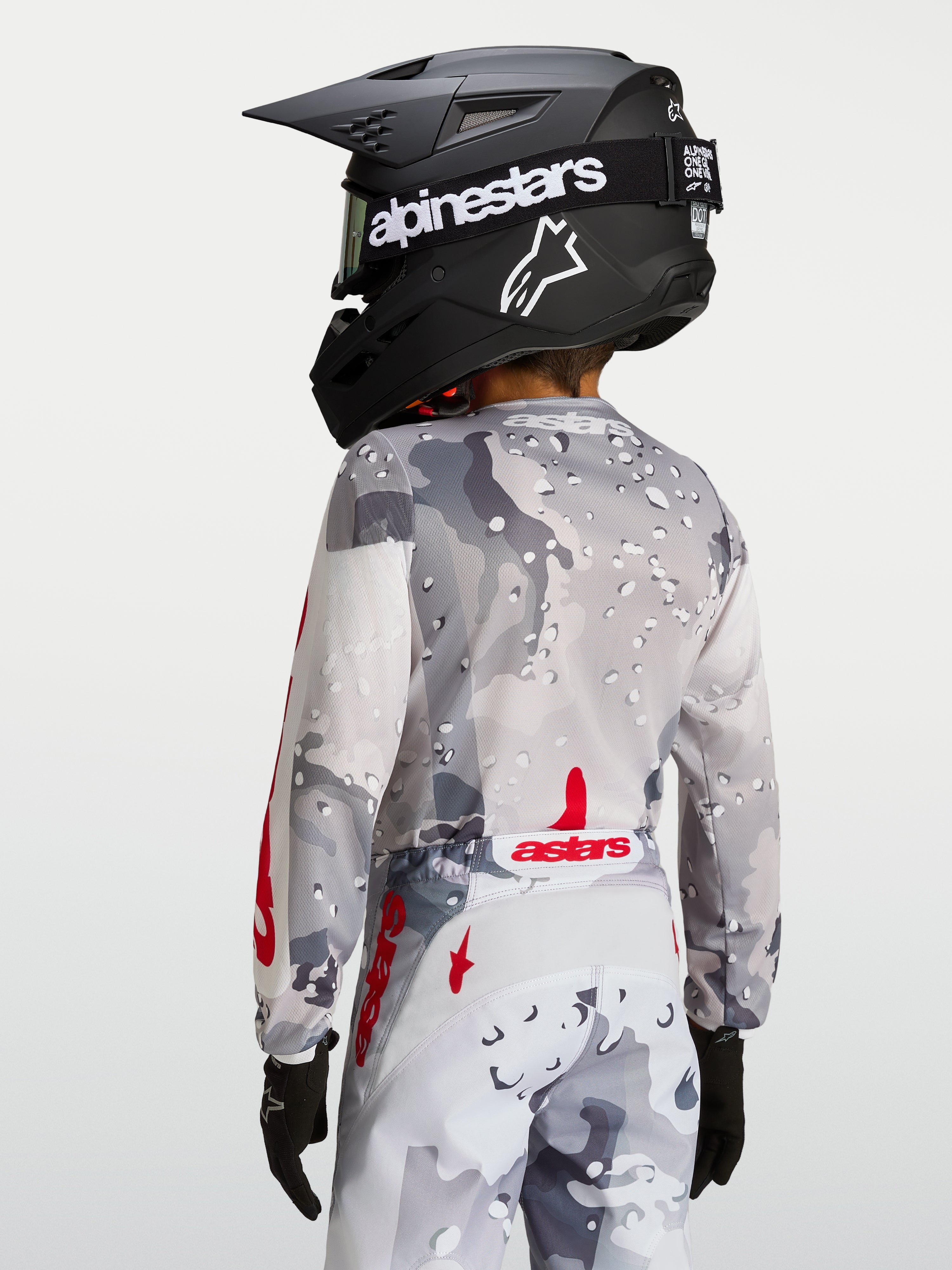 Alpinestars 2027 Ungdom Fluid Lone tröja, grå och röd motocrosströja, vy bakifrån med ergonomisk passform och förlängt bakstycke.