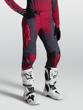 Alpinestars Stella Techstar Swan byxor, röda och mörkgråa motocrossbyxor för damer bärs med vita Tech 10 stövlar.