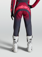 Alpinestars Stella Techstar Swan Pants, women's performance motocross gear, crimson and dark gray, durable 600D polyfabric and stretch ripstop construction, reinforced seat area, on-model rear view with white racing boots.