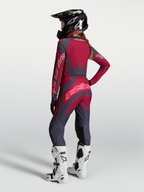 Alpinestars Stella Techstar Swan tröja och gear set, röd och grå motocrossutrustning för dam sedd bakifrån med svan-grafik.